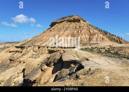 Ein einzelner Hügel erhebt sich in einer kargen Wüstenlandschaft unter einem klaren blauen Himmel, Bardenas Reales Natural Park, Wüste, Halbwüste, Navarra, Nafarroa, UNESCO Stockfoto