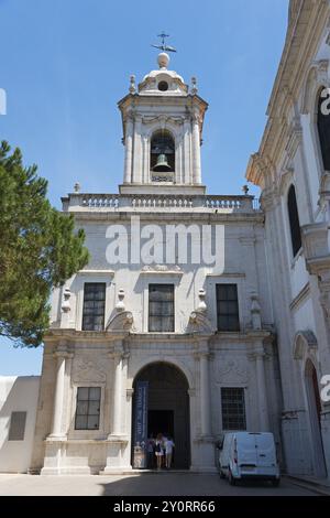 Kleine historische Kirche mit Glockenturm, einige Besucher und umgeben von Bäumen unter blauem Himmel, Kirche und Kloster von Graca, Convento da Graca, Co Stockfoto