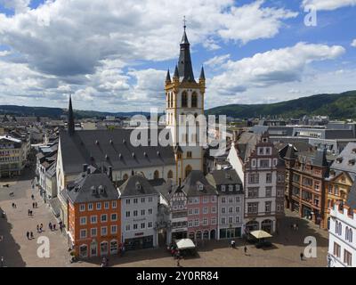 Historische Kirche mit Türmen und umliegenden bunten Gebäuden auf einem belebten Marktplatz in Trier, aus der Vogelperspektive, Kirche St. Gandolf, Hauptmarkt, TR Stockfoto