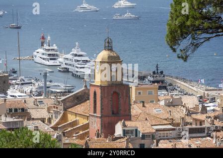 Blick über die Dächer von Saint Tropez mit der Kirche Notre-Dame de l'Assomption, dahinter die Bucht von Saint Tropez mit zahlreichen Booten, Saint Tropez, P Stockfoto