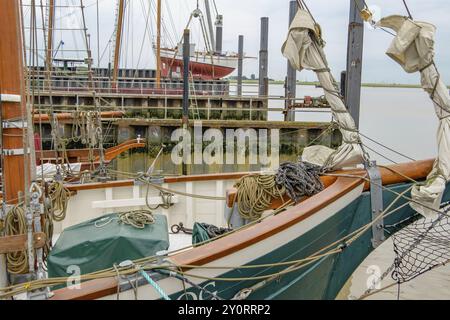 Boote im Hafen, die Wassertiefe ist begrenzt durch alte Holzpfähle, ein ruhiges, maritimes Bild, Ditzum, ostfriesland, deutschland Stockfoto