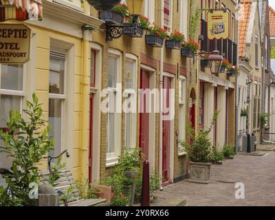 Wunderschöne Altstadtstraße mit bunten Fassaden und blühenden Blumen vor einem Hotel, Delft, Niederlande Stockfoto