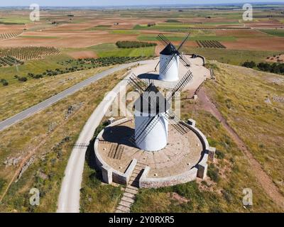 Aus der Vogelperspektive auf zwei weißen Windmühlen mit schwarzen Dächern auf einem Hügel mit Straßen und Feldern, aus der Vogelperspektive, Alcazar de San Juan, Ciudad Real, Castilla-La Mancha Stockfoto