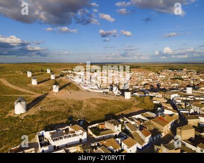 Aus der Vogelperspektive eines Dorfes mit mehreren Windmühlen und Häusern unter blauem Himmel mit Wolken, aus der Vogelperspektive, Windmühlen, Campo de Criptana, Ciudad Real Provin Stockfoto