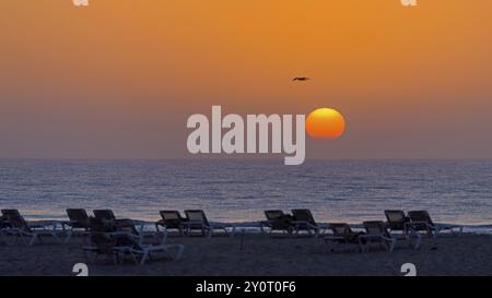 Reiseziel Spanien, Schwimmen im Meer, Reisen, Urlaub, Sonnenaufgang, Liegestühle am Strand, Sonne und Spaß am Strand, weißer Sandstrand, kalter Wind, Stockfoto