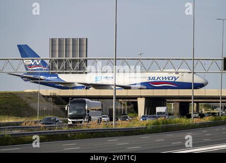 Flughafen Amsterdam Schiphol, Silk Way West Airlines, Frachtflugzeug Boeing 747-4R7F auf dem Rollweg, Brücke über die Autobahn A4, Verbindung vom Polde Stockfoto