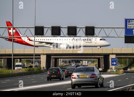 Flughafen Amsterdam Schiphol, Helvetic Airways Embraer ERJ-195, Flugzeug auf dem Rollweg, Brücke über die Autobahn A4, Verbindung von der Polderbaan-Strecke Stockfoto