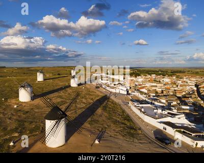 Luftaufnahme von Windmühlen und einem Dorf unter blauem Himmel mit Wolken und langen Schatten, Luftaufnahme, Windmühlen, Campo de Criptana, Provinz Ciudad Real, Stockfoto