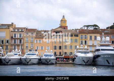 Yachten legen im Hafen von Saint Tropez an, dahinter farbenfrohe Häuser und die Kirche Notre-Dame de l'Assomption, Saint Tropez, Provence-Alpes-Cot Stockfoto