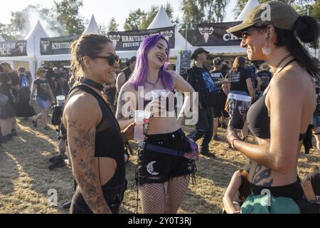 Drei Frauen plaudern im Wacken Open Air in Wacken. Das traditionelle Metal Festival findet vom 31. Juli bis 2. August 2024 statt Stockfoto