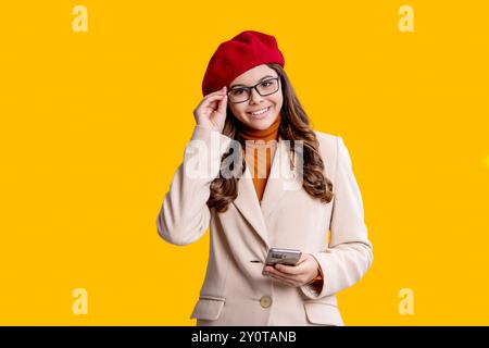 Surfen im Internet und Bloggen. Chatten und SMS schreiben. Teenager-Mädchen chatten online isoliert gelb. Einkaufsrabatt. Teenager-Mädchen bloggt am Telefon. Modern Stockfoto