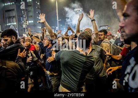 Israelische Demonstranten werden während einer Demonstration außerhalb des Verteidigungsministeriums von Polizisten in Normalkleidung zurückgeschoben. Tausende von Menschen haben sich in Tel Aviv und in ganz Israel versammelt, drei Tage nachdem die Leichen von Karmel Gat, Eden Yerushalmi, Hersh Goldberg-Polin, Alexander Lobanov, Almog Sarusi und Meister Sgt Ori Danino aus Gaza gerettet wurden. Die Demonstranten rufen Premierminister Benjamin Netanjahu und seine Regierung auf, eine Einigung zu erzielen, um die Freilassung der verbleibenden Geiseln zu erreichen, die die Hamas während der Angriffe vom 7. Oktober ergriffen hat. Stockfoto