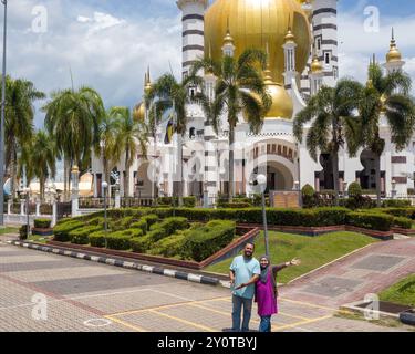 PERAK, MALAYSIA - 18. Oktober 2022: Muslimisches Paar mit der Ubudiah-Moschee in Kuala Kangsar. Stockfoto