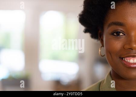 Lächelnde afroamerikanerin mit Ohrring zu Hause, Nahaufnahme, Kopierraum Stockfoto