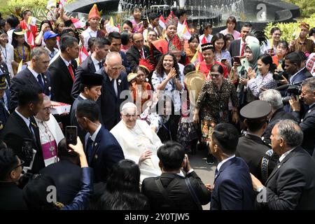 Jakarta, Indonesien. September 2024. Papst Franziskus und Indonesiens Präsident Joko Widodo (hinter dem Papst) werden nach einem Treffen mit den indonesischen Behörden, der Zivilgesellschaft und dem diplomatischen Korps am 4. September 2024 im Präsidentenpalast in Jakarta, Indonesien, von Wohlwollenden begrüßt. In 12 Tagen vom 2. Bis 13. September besucht Papst Franziskus Indonesien, Papua-Neuguinea, Osttimor und Singapur. Es ist die 45. Reise des Pontifikats von Franziskus und bringt die Länder, die er besucht haben wird, nach 65. Foto von (EV) Vatican Media/ABACAPRESS. COM Credit: Abaca Press/Alamy Live News Stockfoto