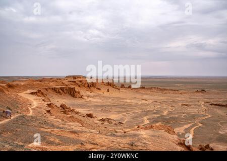 Eine junge Frau sucht nach Dinosaurierknochen an den Flaming Cliffs in der Wüste Gobi in der Mongolei. Stockfoto