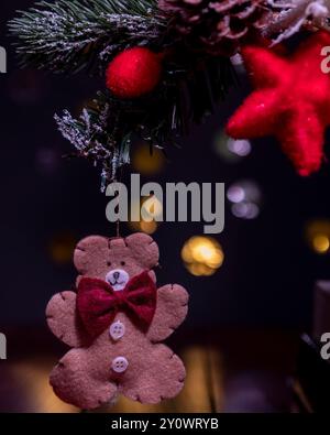Eine Weihnachtsbaumkugel in Form eines Lebkuchenkekses mit Bokeh-Lichtern im Hintergrund Stockfoto