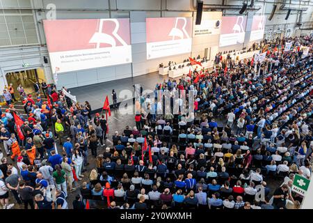 Wolfsburg, Deutschland. September 2024. Mitarbeiter warten auf den Beginn einer Werkbesprechung in einer Halle des VW-Werks. Volkswagen hat angekündigt, seine Sparmaßnahmen aufgrund der angespannten Lage der Kernmarke zu verschärfen. Selbst obligatorische Entlassungen und Werksschließungen können nicht mehr ausgeschlossen werden. Kredit: Moritz Frankenberg/dpa Pool/dpa/Alamy Live News Stockfoto