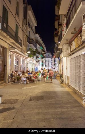 Sitges, Barcelona-04. September 2024: Bild, das die intime und kulturelle Atmosphäre eines Spaziergangs durch Sitges nach Einbruch der Dunkelheit feststellt. Stockfoto