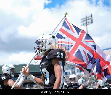 31. August 2024: Hawaii Rainbow Warriors Defensive Back Kilinahe Mendiola-Jensen #29 hält die hawaiianische Flagge, während sie vor dem NCAA-Football-Spiel zwischen den UCLA Bruins und den University of Hawaii Rainbow Warriors im Clarence T.C. Ching Complex in Honolulu, Hawaii, auf dem Spielfeld rennen. Glenn Yoza/CSM Stockfoto