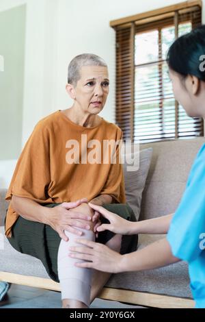 Ältere Frau, die zu Hause Physiotherapie mit einer Pflegeperson erhält Stockfoto