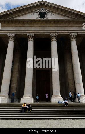 Menschen, die auf den Stufen der Kathedrale St. Pierre von Genf sitzen Stockfoto