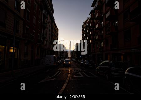 Die letzten Lichtstrahlen führen sanft den Weg zum Jet d'eau in Genf entlang einer schwach beleuchteten Straße, während der Himmel allmählich dunkel wird Stockfoto