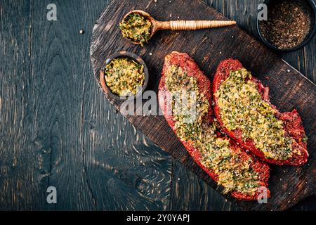 Zwei rohe Rindersteaks, mariniert mit Kräutern und Gewürzen Stockfoto