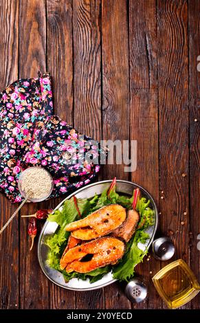 Gebratene Lachssteaks mit frischem Salat auf Metallteller Stockfoto