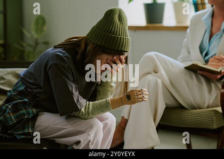 Junge Frau, die in emotionaler Not das Gesicht mit der Hand bedeckt Stockfoto