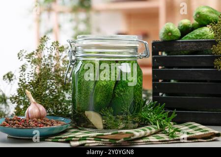 Eingelegte Gurken im Glas, Kräuter und Gewürze auf dem Tisch, Nahaufnahme Stockfoto