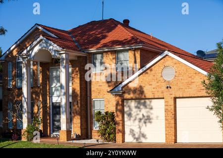 Sydney, NSW, Australien - 2. September 2024. Die Sonne am frühen Morgen trifft auf ein modernes, zweistöckiges Haus aus Ziegelfurnier im äußeren Vorort Sydney. Stockfoto