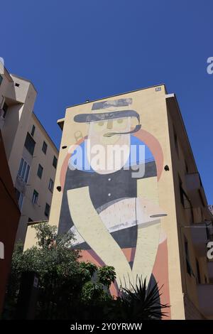 IL Pescatore (der Fischer), ein riesiges Streetart-Werk von Agostino Lacurci, besetzt die gesamte Endwand eines Wohnblocks in Civitavecchia, Italien. Stockfoto