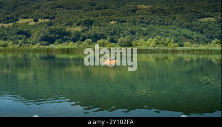 Vater und Tochter fahren an einem sonnigen Tag mit dem Kajak auf dem See Stockfoto