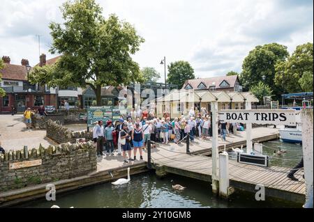 Leute, die am Ufer warten, um an Bord einer Bootsfahrt zu gehen, die von der French Brothers Boat Tour Agency durchgeführt wird. Windsor Berkshire England Vereinigtes Königreich Stockfoto