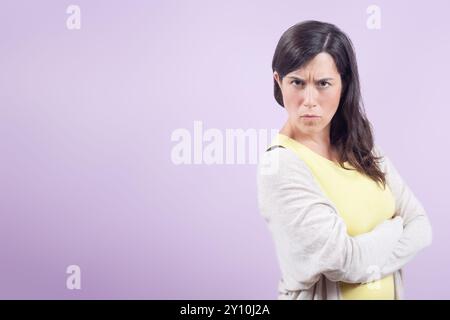 Frau mit überkreuzten Armen schaut wütend in die Kamera. Das Konzept von Frustration und Trotz. Stockfoto