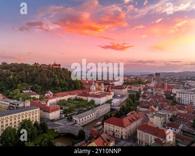 Blick aus der Vogelperspektive auf das Zentrum von Ljubljana Slowenien mit historischen Gebäuden, roten Dachhäusern auf dem Hügel, Kirchen in der slowenischen Hauptstadt Sonnenuntergang farbenfrohe s Stockfoto