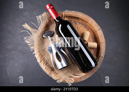 Flügelkorkenzieher, Flasche Wein, Korken und Holzfässer auf grauem Tisch, Draufsicht Stockfoto