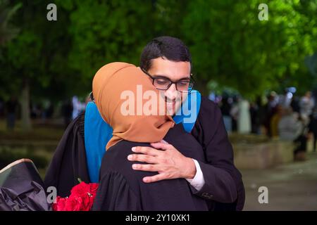 Ein wunderbarer Moment zwischen Bruder und Schwester, der nachts den Abschluss des Bruders feiert Stockfoto