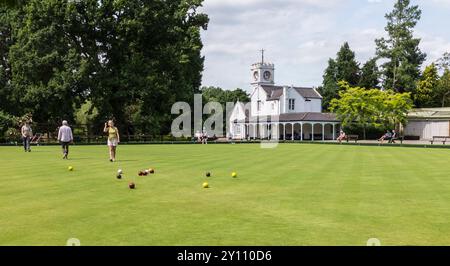 Ein sonniger Tag auf dem Bowling Green im South Park, Darlington, England, Großbritannien, mit zwei Männern und zwei Frauen, die Bowls spielen Stockfoto