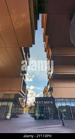 Amsterdam, Niederlande - 15. März 2024: Blick nach oben auf den modernen architektonischen Komplex mit geometrischer Fassade, die „NEXT“ zeigt. Storefront VERSCHIEBEN und Drag-and-Drag-out Stockfoto