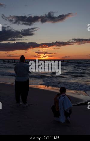 Zwei Personen genießen den Sonnenuntergang an der Ostsee, Zingst, Mecklenburg-Vorpommern, Deutschland Stockfoto