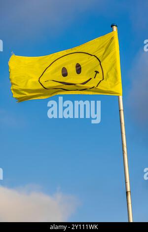 Lächelnde Flagge gegen blauen Himmel Stockfoto