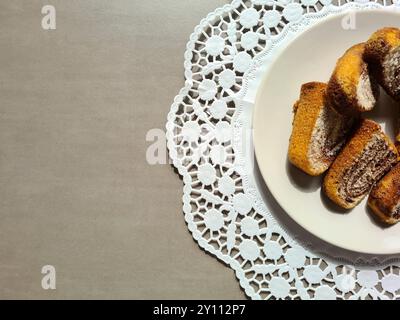 Einzelne Marmorkuchen auf einem weißen Teller auf einer runden dekorativen Papierkuchenauflage auf grauem Hintergrund serviert Stockfoto