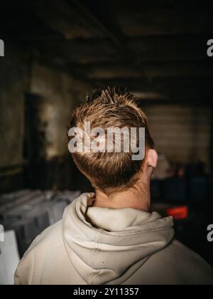 Junger Mann mit Kapuze im Lagerhaus Stockfoto