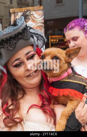 England, East Sussex, Hastings, das jährliche Pirate Day Festival, Porträt der farbenfrohen weiblichen Teilnehmerin, die Haustier-Hund hält Stockfoto