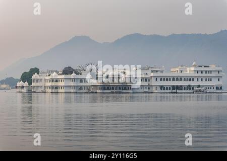 Künstlerische Palastarchitektur am unberührten See und nebligen Bergkulissen am Morgen wird in Udaipur rajasthan india aufgenommen. Stockfoto