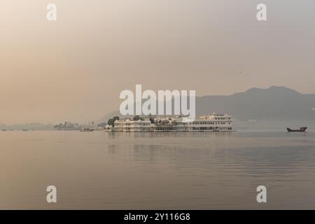 Künstlerische Palastarchitektur am unberührten See und nebligen Bergkulissen am Morgen wird in Udaipur rajasthan india aufgenommen. Stockfoto