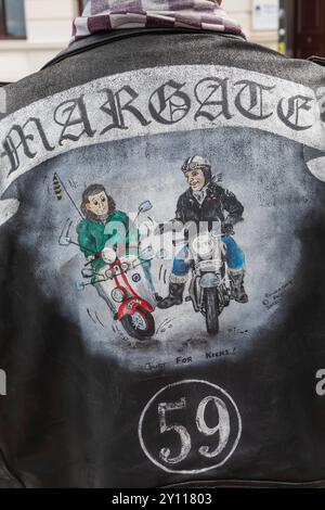 England, Kent, Margate, die Big 7 National Scooter Rally, Rückansicht der Lederjacke für ältere Männer mit Artwork, das Rocker auf dem Motorcycle Kicking Mod auf Roller zeigt Stockfoto