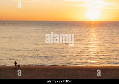 England, Kent, Kingsgate Bay, man and Dog on Beach at Sunrise Stockfoto